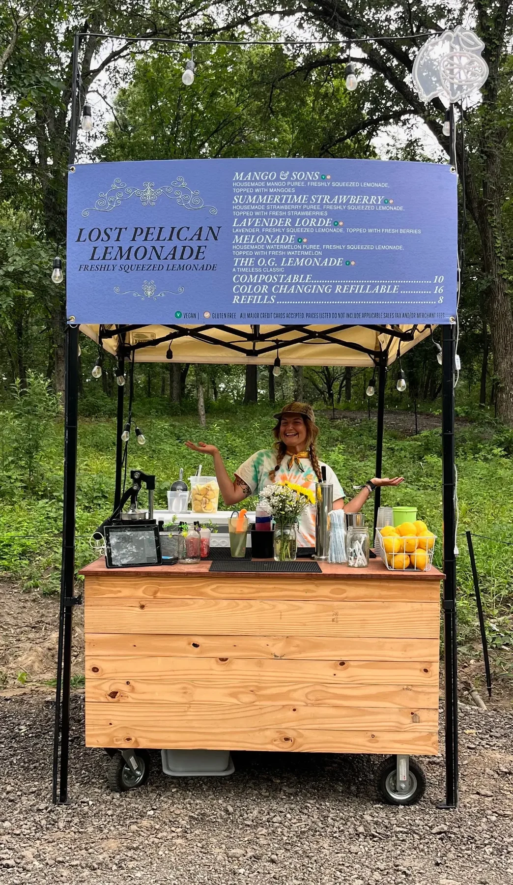 Lost Pelican Lemonade festival booth with fresh lemons and a smiling team member